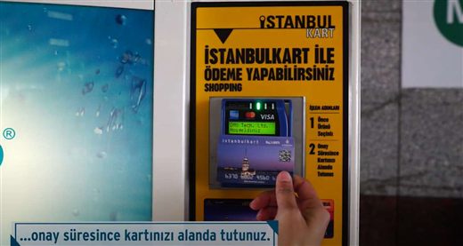 The water machine's payment device with the transit card presented — the screen reads DMS Tech