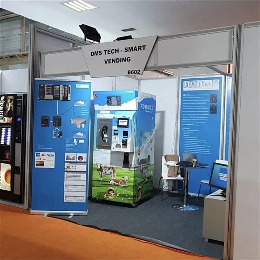 Our own stand that year — "DMS TECH · SMART VENDING, B602" — with the PLC-driven milk dispenser on it, the machine that had neither MDB nor Executive